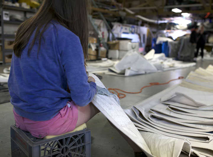 A sailmaker repairing a sail