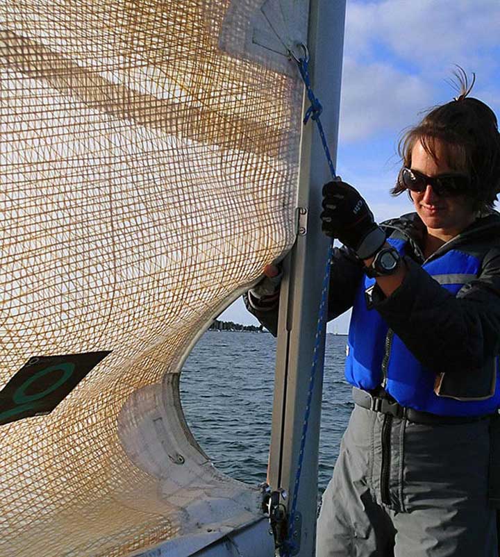 A sailor reefing a mainsail