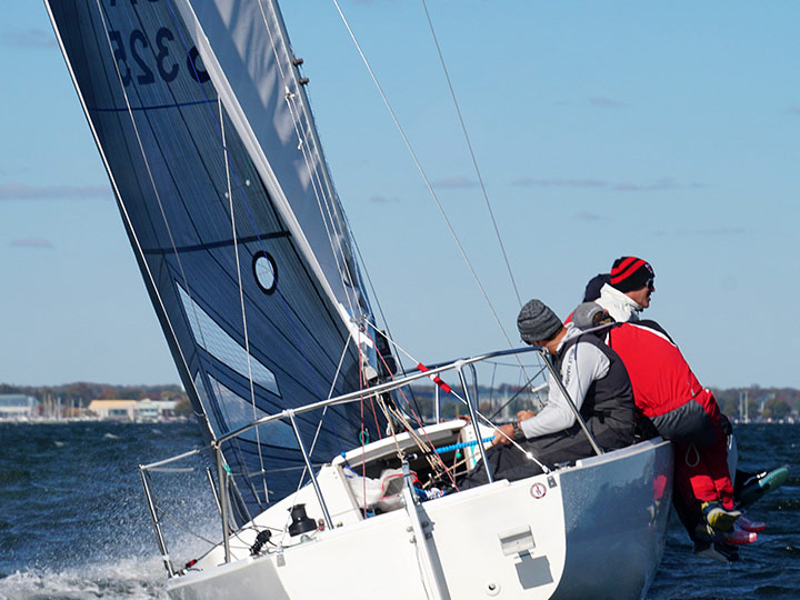 A j/24 crew racing upwind flying a Quantum Mainsail and Genoa