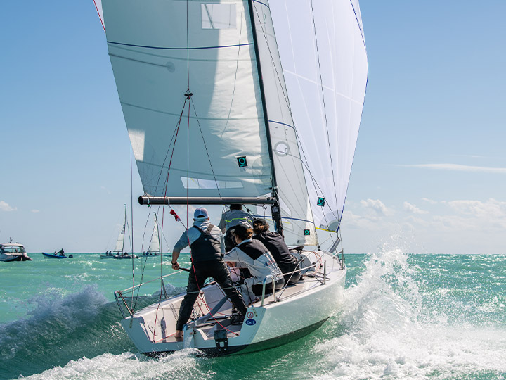 A J/70 crew racing downwind flying Quantum sails