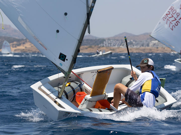 An optimist sailor racing downwind with a Quantum sail.